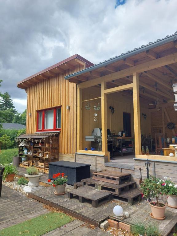 een klein houten huis met een picknicktafel en banken bij Ferienbungalow "Outdoor" in Bad Schandau