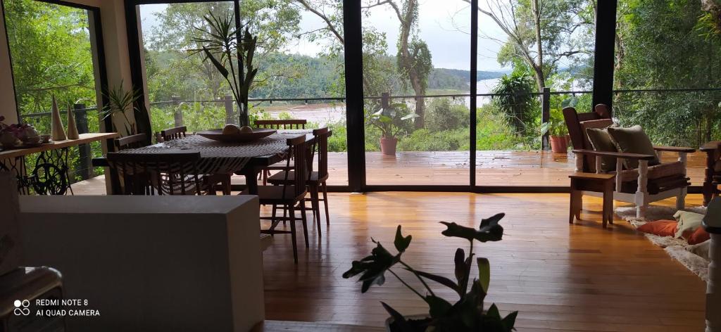 comedor con mesa y sillas y ventana grande en Vista al Rio Arami 