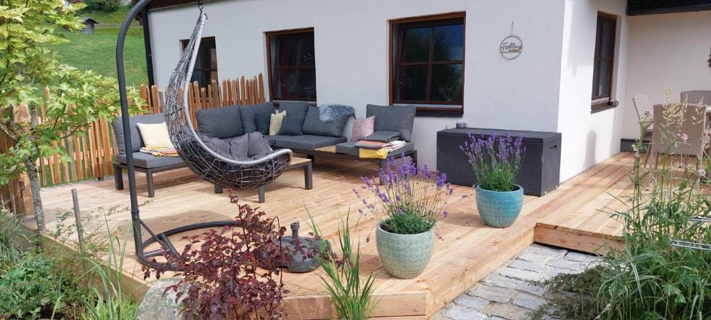 een patio met een hangmat op een houten terras bij Ferienhaus Sommerbichl in Zell am See
