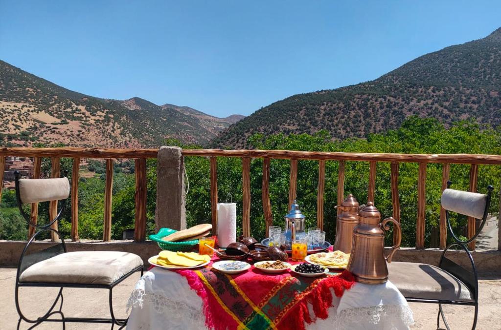 uma mesa com comida numa varanda com montanhas em Atlas Imsker em Marrakech