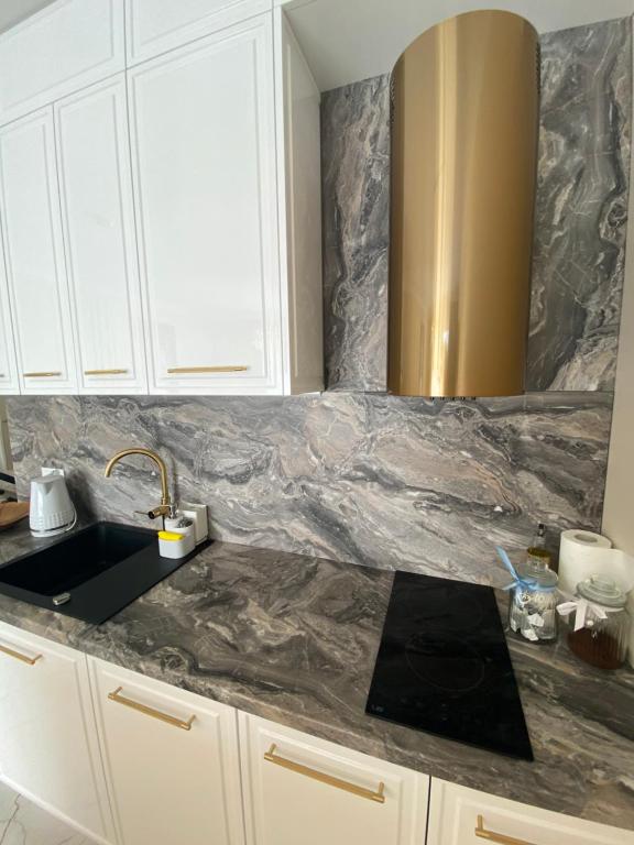 a kitchen with a marble counter top and a sink at Glamor Lux in Gdańsk