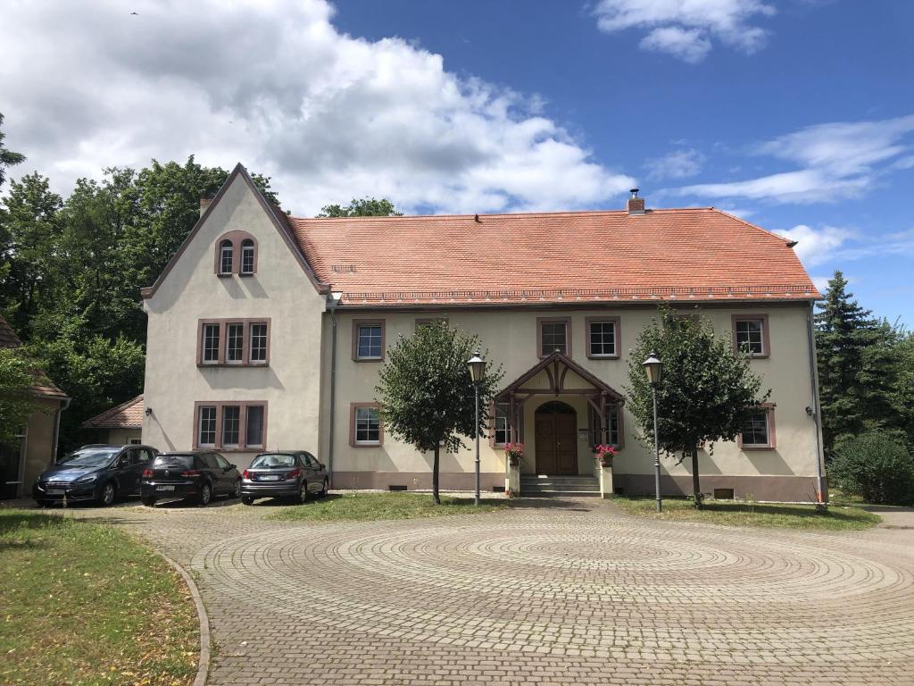 a large house with cars parked in front of it at Ferienwohnung "Altes Schloss Wilhelmsfeld" 