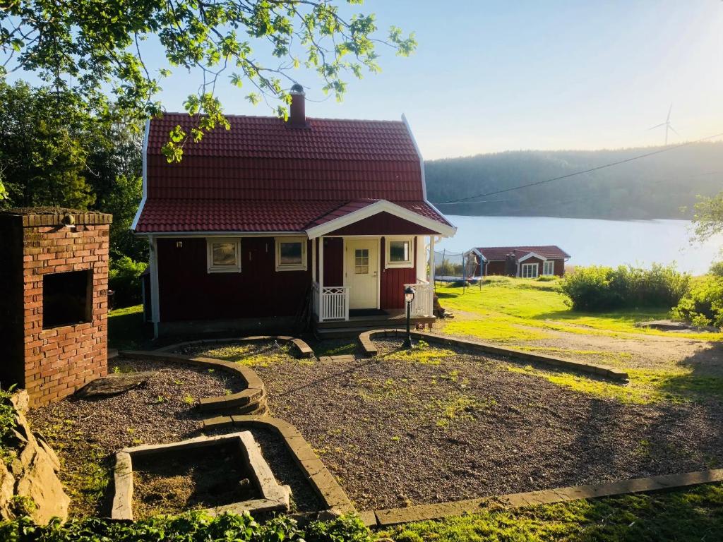 une petite maison avec un toit rouge et une cour dans l'établissement Lovely holiday house by a beautiful lake!, à Svenshögen