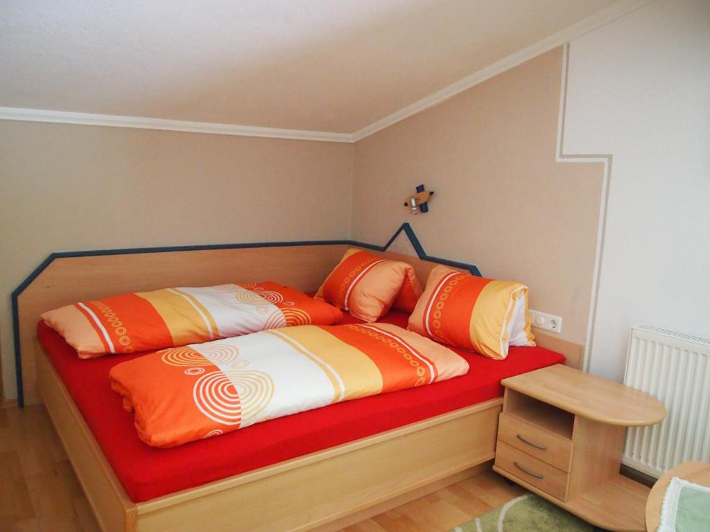een bed met oranje en witte kussens erop bij Haus Agnes Daum in Hippach
