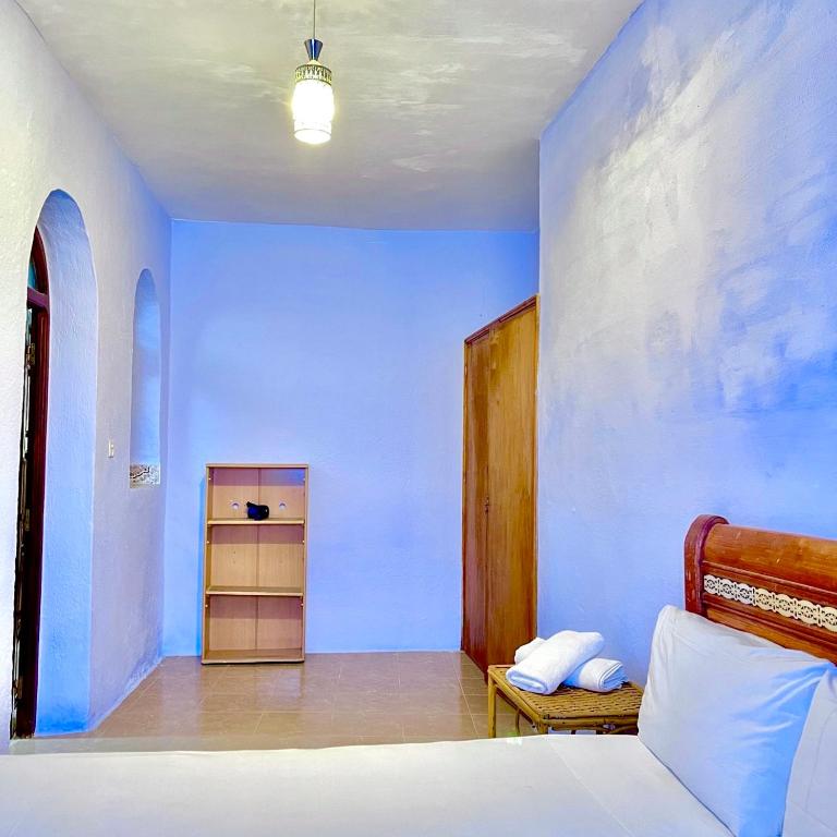 a bedroom with a bed and a blue wall at Oldtown House in Chefchaouene