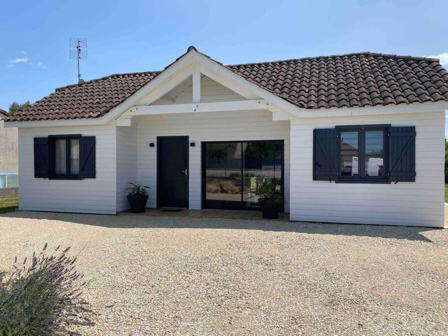 une maison blanche avec une porte et des fenêtres noires dans l'établissement Le Val des Prats proche de Rocamadour, à Puybrun