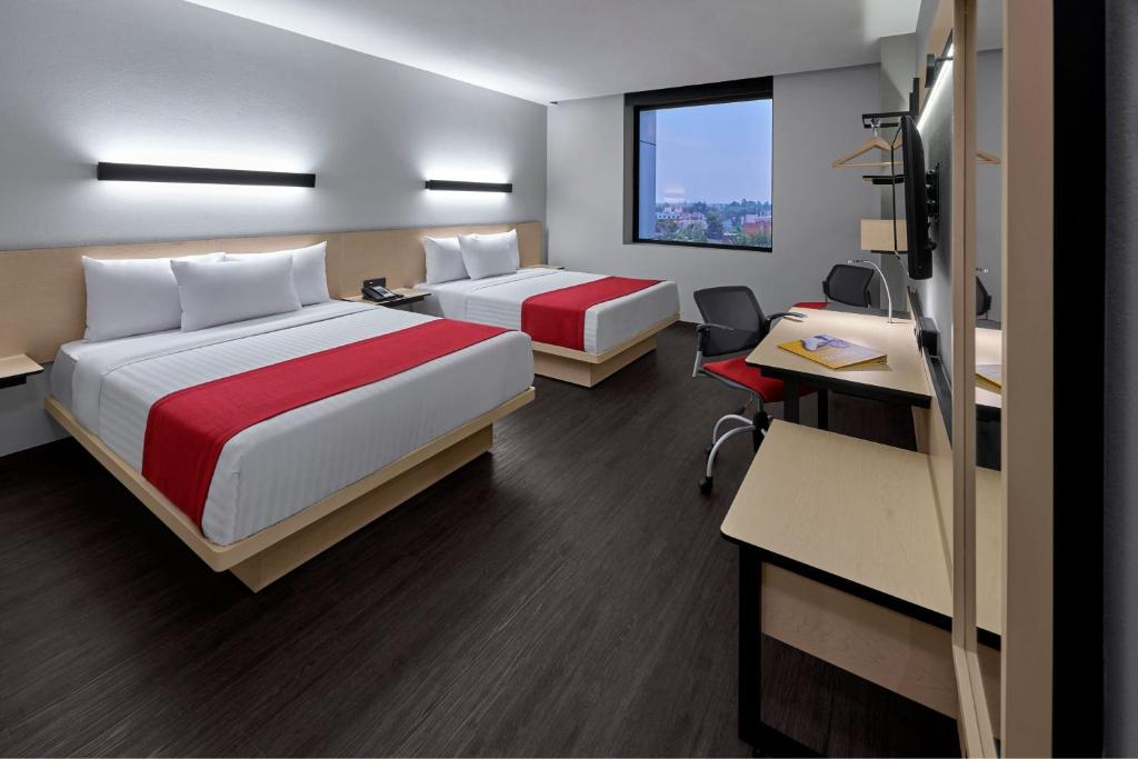 a hotel room with two beds and a desk at City Express by Marriott Ciudad de México Tlalpan in Mexico City