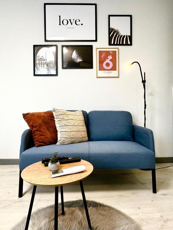 a blue couch in a living room with a table at Chic Studio in Timişoara