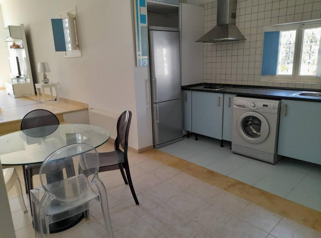 a kitchen with a table and a washing machine at Villa "LAGUNA" à 500 m de la plage - DJERBA in Houmt Souk