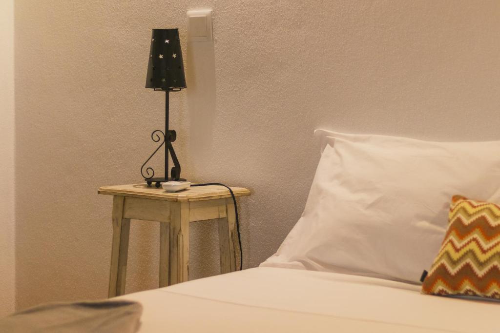 une lampe assise sur une table à côté d'un lit dans l'établissement CASAS DA RUA NOVA, à Alijó