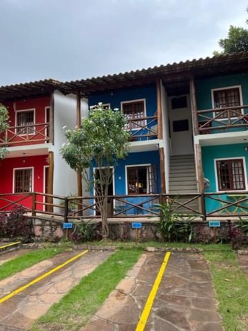 a blue and white building with a tree in front of it at Vivendas do Serrano Apart105 Lençois in Lençóis