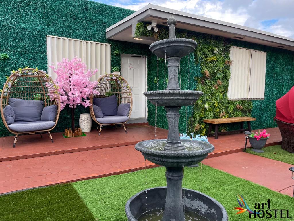einen Brunnen in der Mitte eines Gartens mit zwei Stühlen in der Unterkunft Art Gardens Wynwood concept in Miami