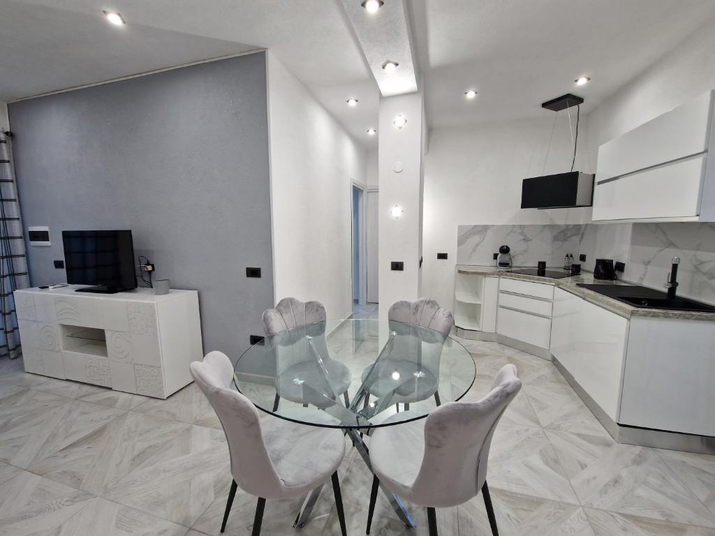a dining room with a glass table and chairs at La Maddalena Holiday Home in La Maddalena