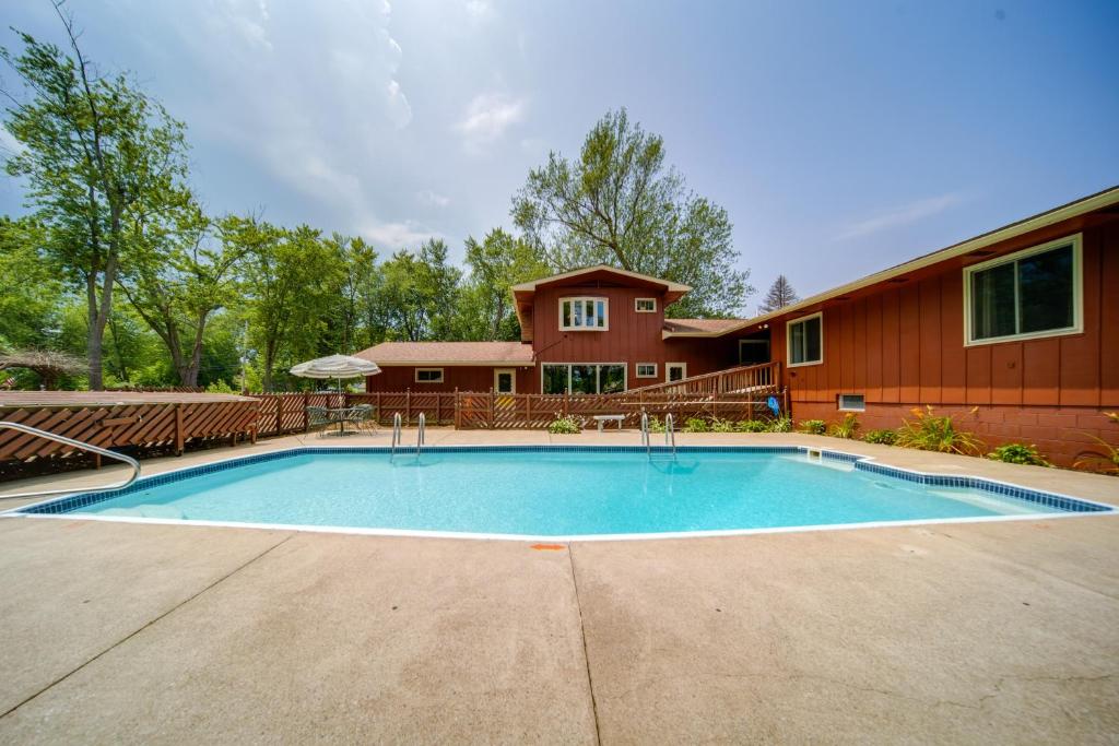 a large swimming pool in front of a house at Lake Erie Getaway with Private Pool and Yard! in Conneaut