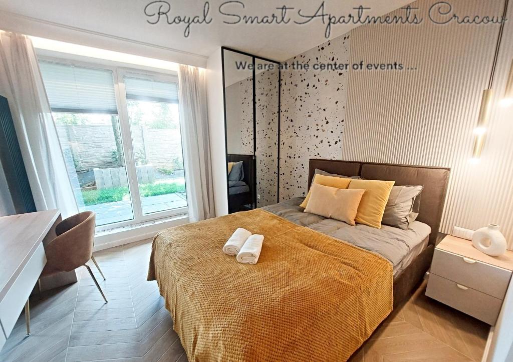 1 dormitorio con 1 cama con 2 toallas en Royal Smart Apartments Cracow en Cracovia