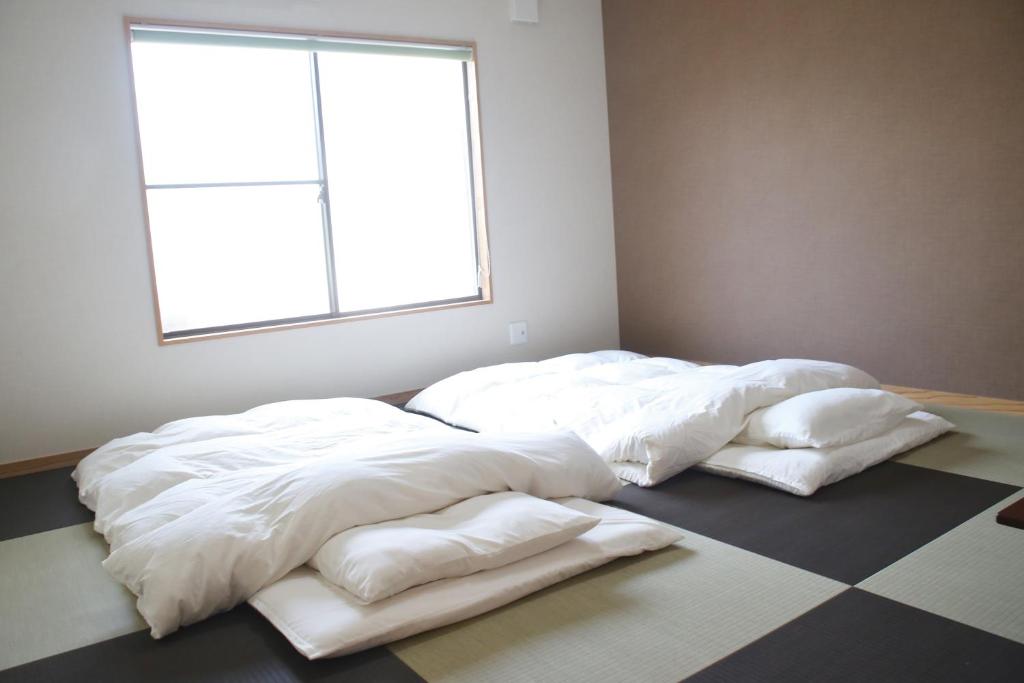 two large white beds in a room with a window at Kyoto Nishijin no Yado in Kyoto