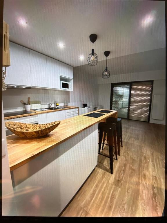 uma cozinha com armários brancos e um balcão de madeira em Le Mimosas em Mandelieu-la-Napoule