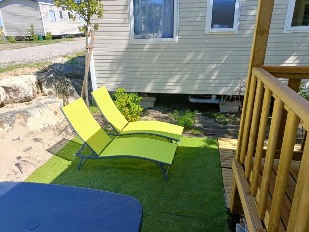a pair of yellow chairs sitting on a deck at mobil-home neuf 4-6 places camping Siblu les viviers in Lège-Cap-Ferret