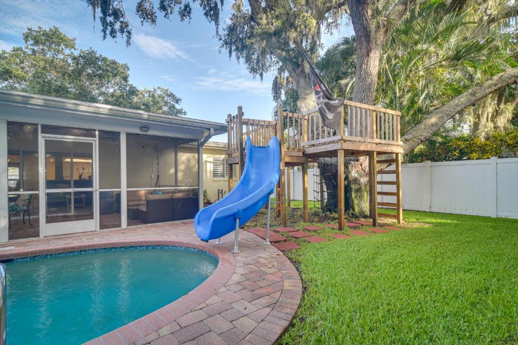 um parque infantil em frente a uma casa com um escorrega azul em Largo Retreat with Private Pool, Slide and Treehouse! em Largo