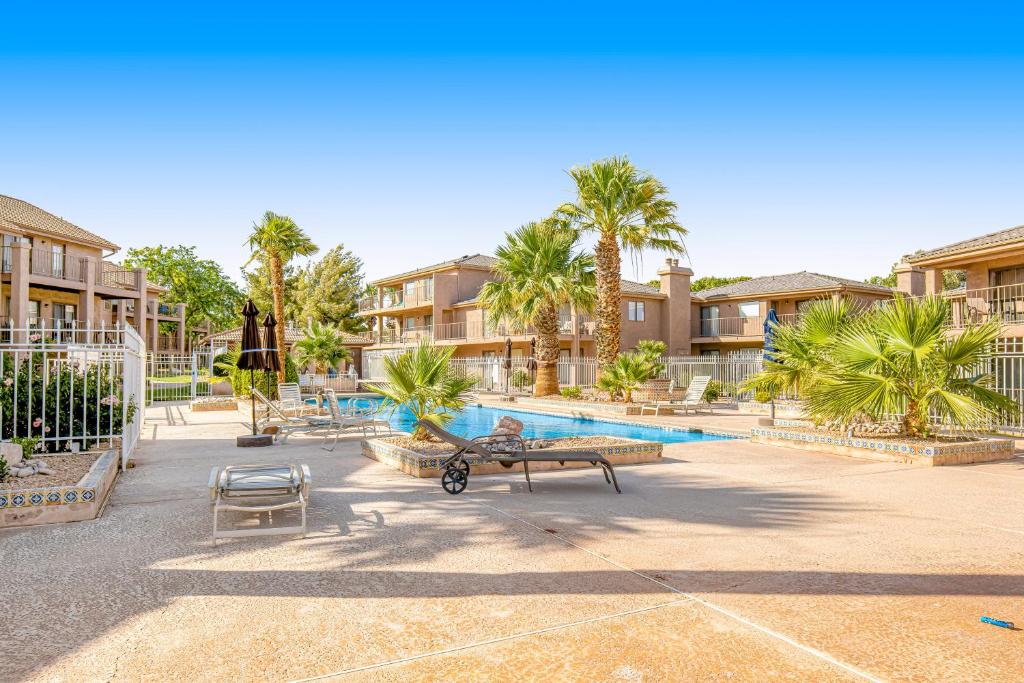 a resort with a pool with palm trees and condos at Southern Utah Realness in St. George