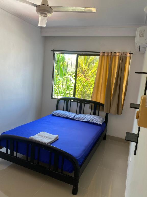 1 dormitorio con cama y ventana en Casa a una cuadra del mar, en Tolú