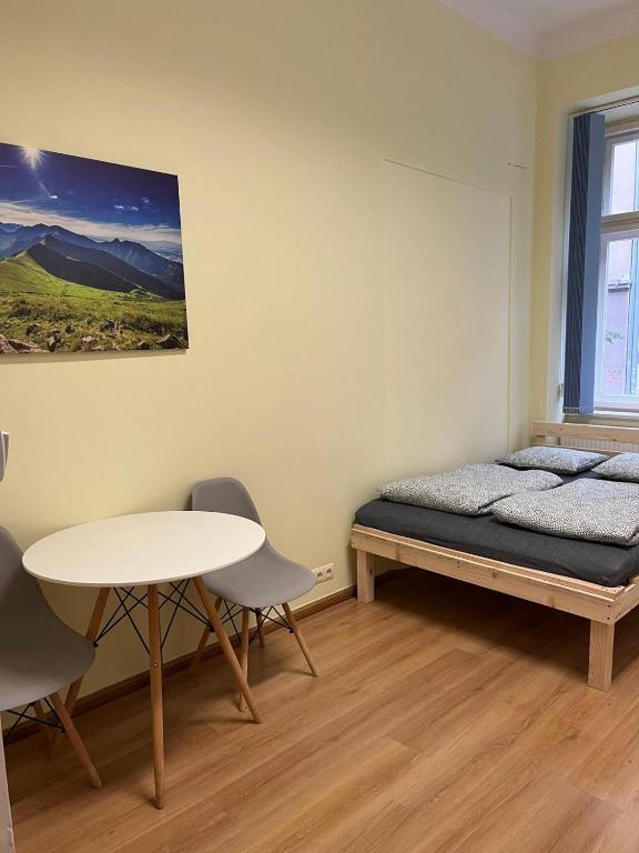 1 dormitorio con 1 cama, mesa y sillas en Batorego Lovely Rooms en Cracovia