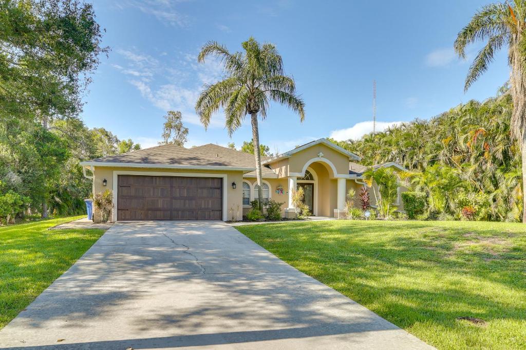 uma casa com palmeiras e uma entrada em Private Fort Myers Escape with Screened Pool and Lanai em Fort Myers