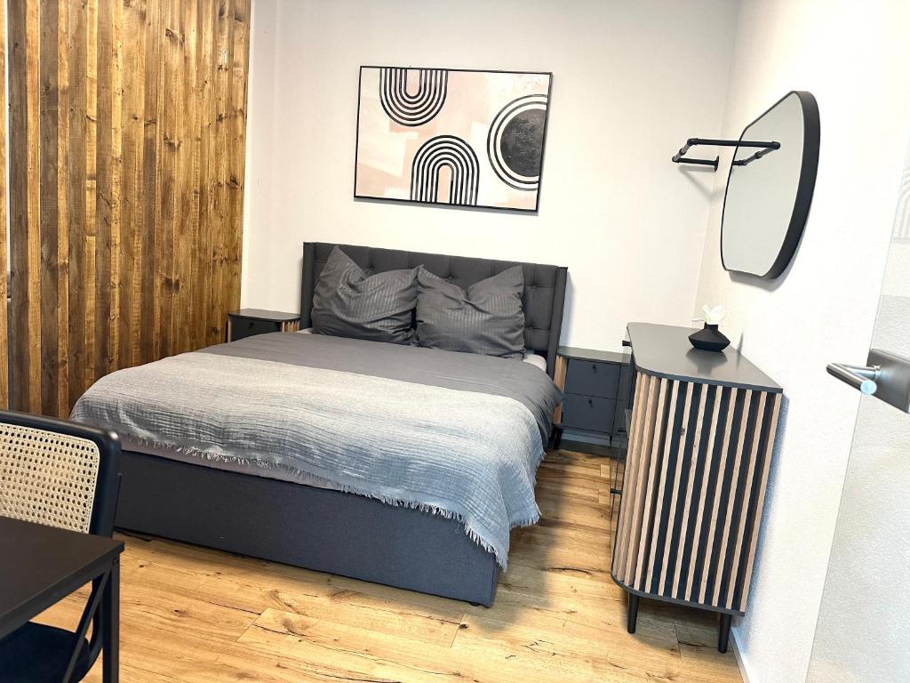 ein Schlafzimmer mit einem Bett, einem Tisch und einer Lampe in der Unterkunft Moderne Erdgeschosswohnung in Augsburg