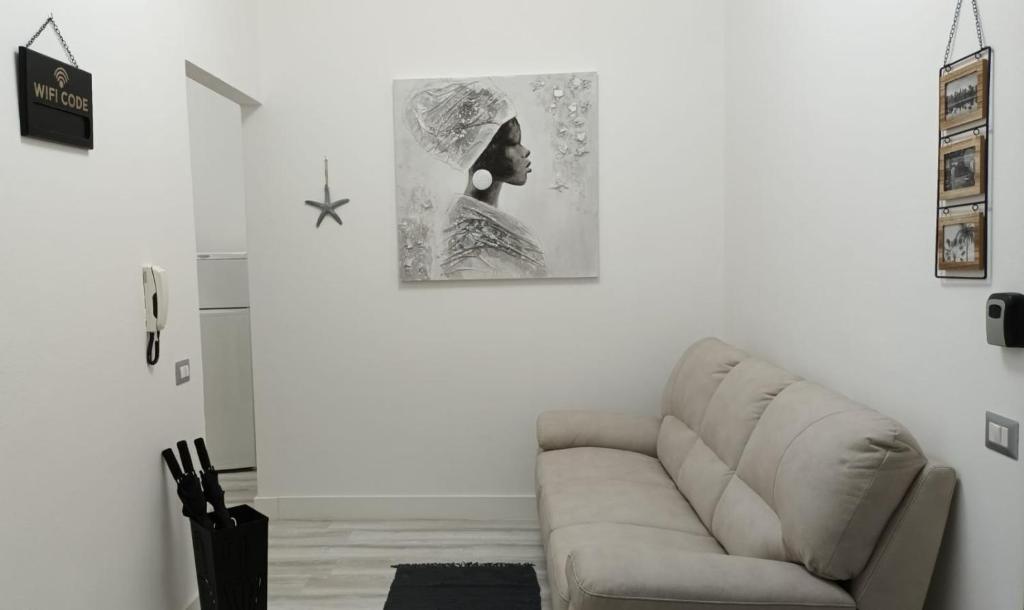 ein Wohnzimmer mit einem Sofa und einem Bild an der Wand in der Unterkunft La Laguna Rooms in SantʼAntìoco
