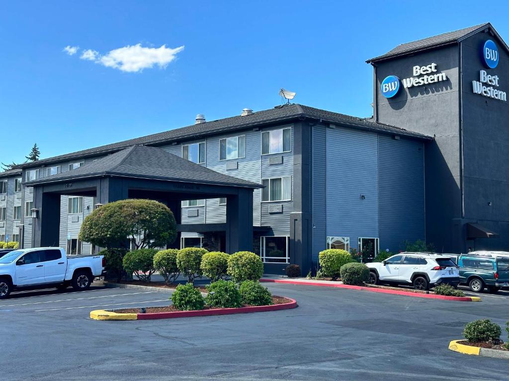 un hôtel avec des voitures garées dans un parking dans l'établissement Best Western Cascade Inn & Suites, à Troutdale