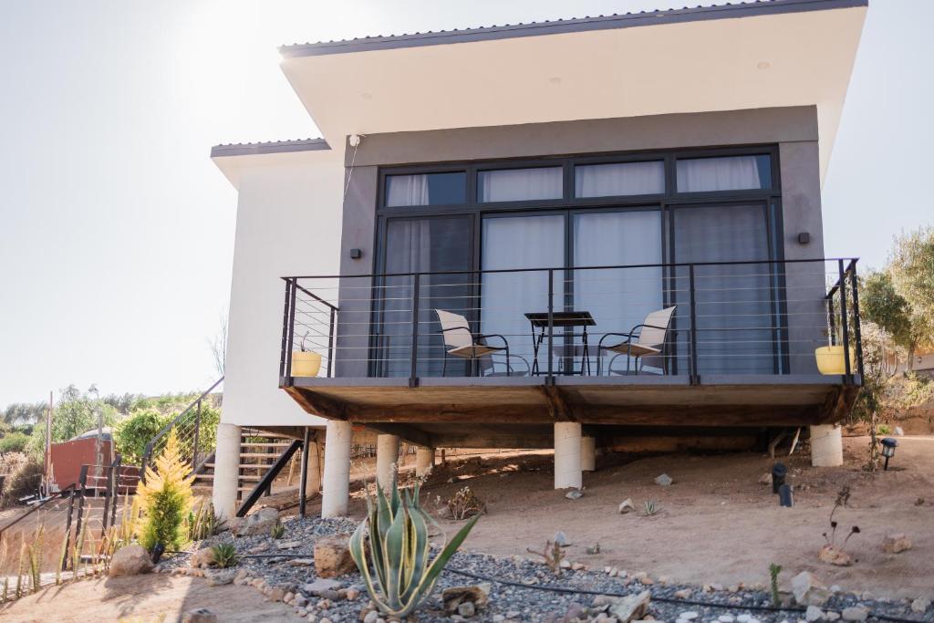 a house with a balcony with a table and chairs at Starlight bungalow queen 4 in El Porvenir