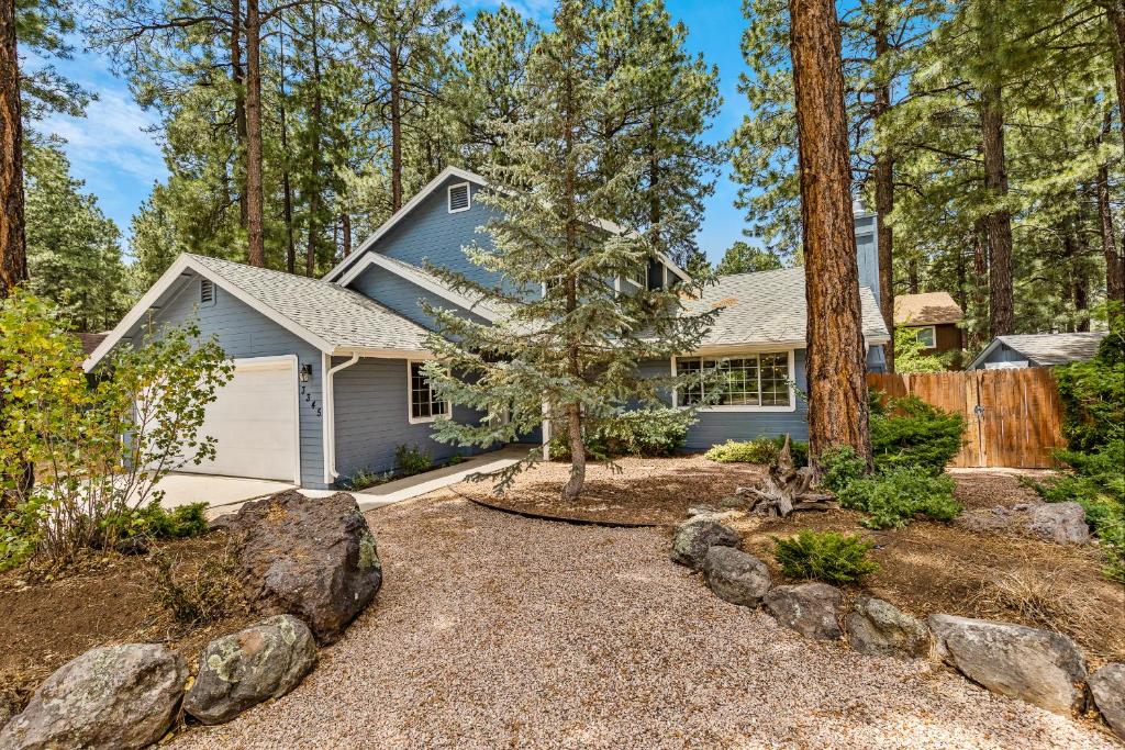a home in the woods with a gravel driveway at Family Friendly Escape~ Close to Downtown ~Airport ~Sedona & Grand Canyon in Flagstaff