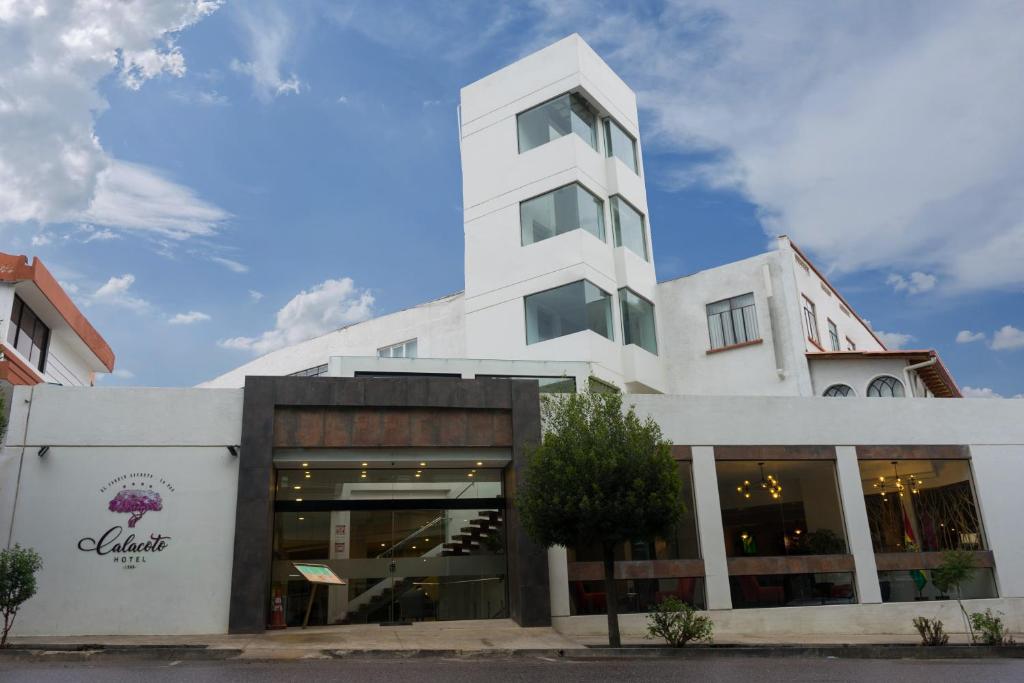 a white building with a store in front of it at Hotel Calacoto in La Paz