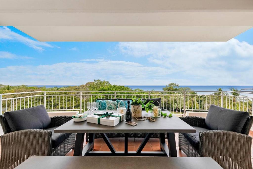 a balcony with a table and chairs and the ocean at Harbour Haven - A Parkside CBD Address in Larrakeyah