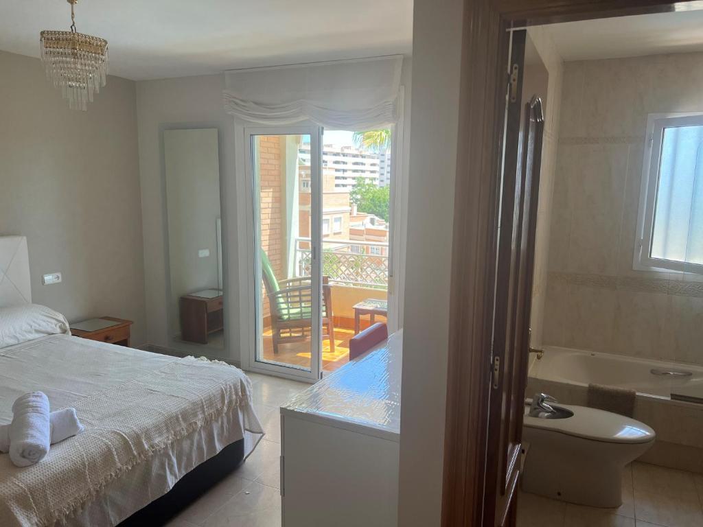 a bedroom with a bed and a bathroom with a tub at HABITACIONES CACHEMIRES en ALMERIA in Almería