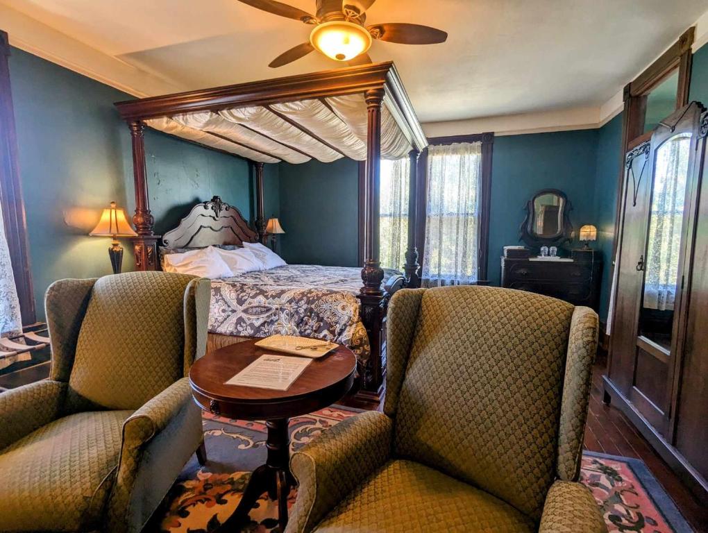 a bedroom with a bed and two chairs and a table at Swantown Inn in Olympia