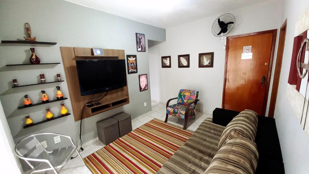 a living room with a couch and a flat screen tv at Apartamento na Praia Grande in Praia Grande