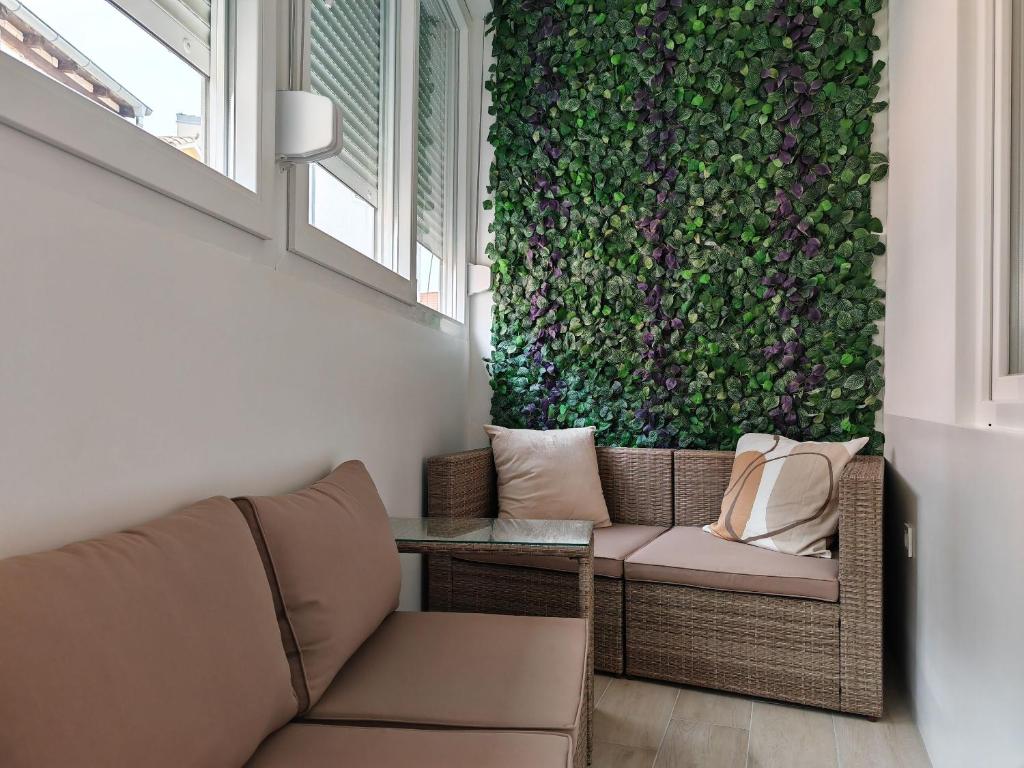 sala de estar con sofá y pared verde en Apartments Mateo en Vodice
