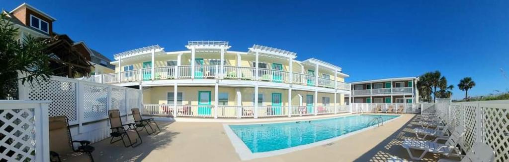 a large house with a swimming pool in front of it at The Savannah Inn in Carolina Beach