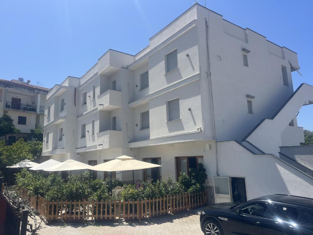 a white building with umbrellas in front of it at Casa Vacanze Tortora in Tortora