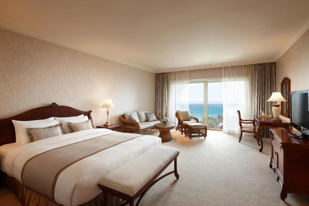西歸浦的住宿－濟州樂天酒店，酒店客房设有一张大床和一台电视。