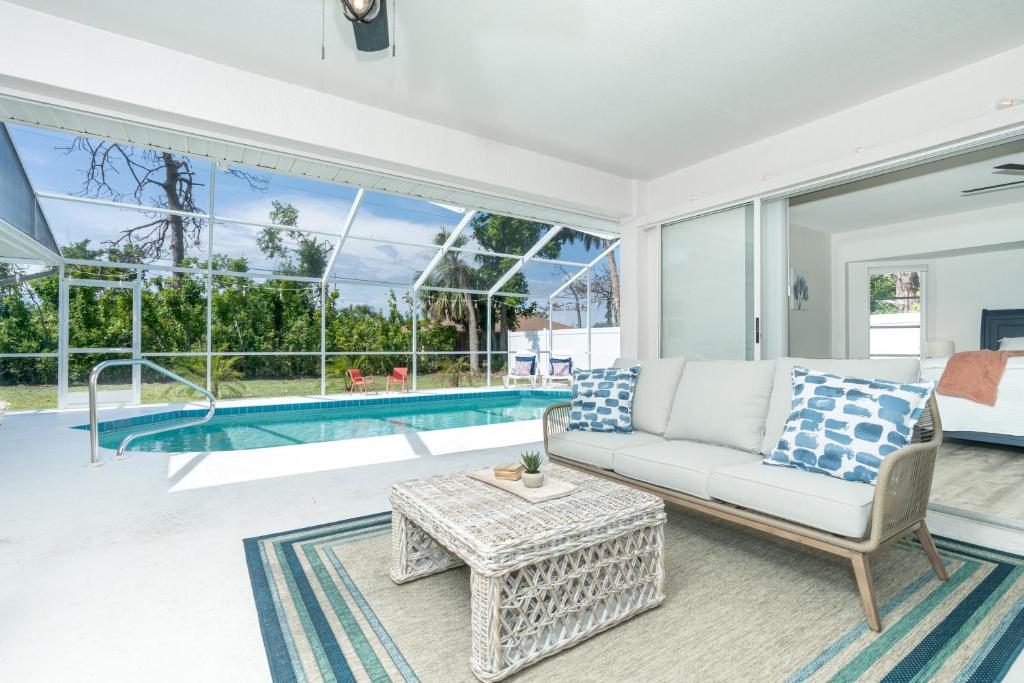 a living room with a couch and a table and a pool at Beautiful Spacious Home! Close to Beaches - HEATED Private Pool in Englewood