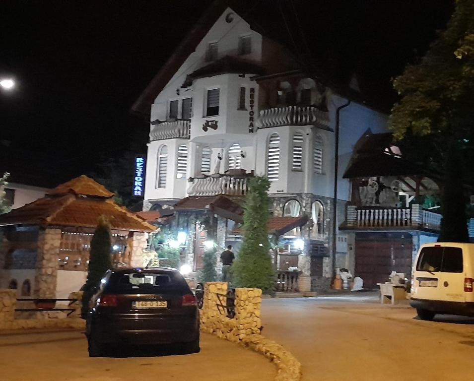 ein Auto, das nachts vor einem Gebäude parkt in der Unterkunft Apartments Daut's Tower in Sarajevo