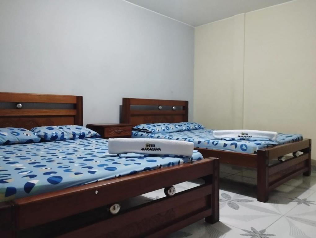 two twin beds in a room withthritisthritisthritisthritisthritisthritisthritisthritisthritis at HOTEL MARACANA in Bucaramanga