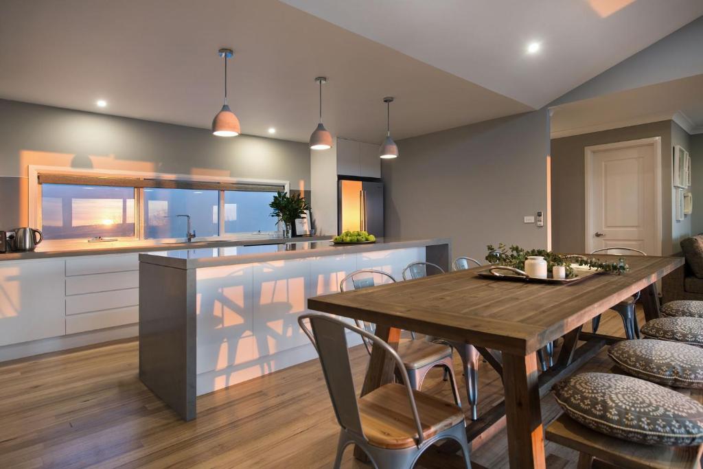 a kitchen and dining room with a wooden table and chairs at Quartz Retreat in Daylesford