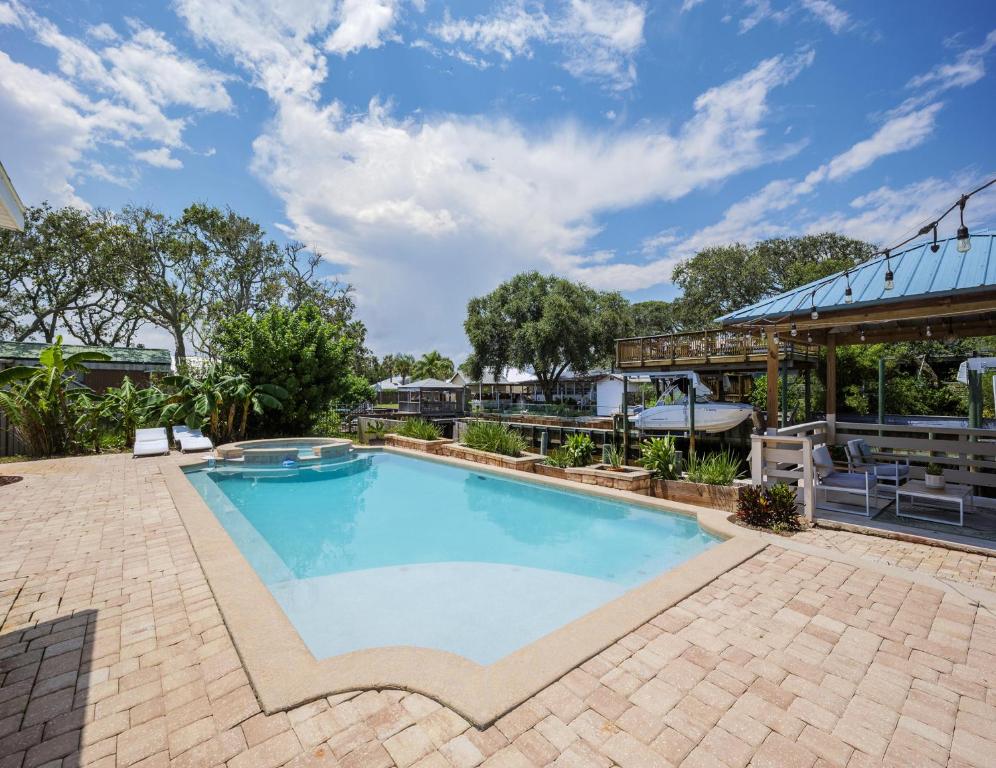 una gran piscina con patio y un edificio en Villa Ventura, en Butler Beach