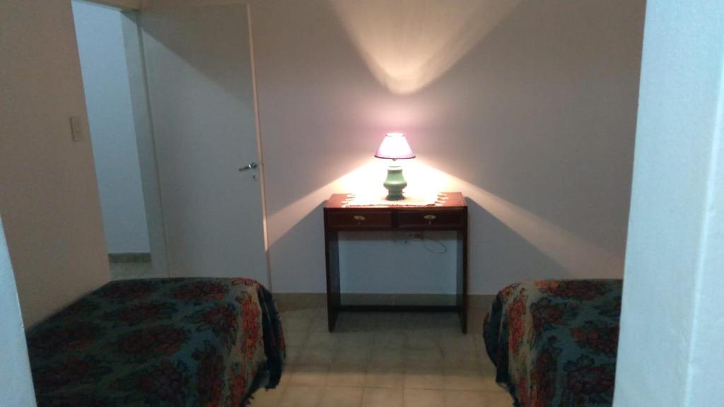 Habitación con 2 camas y una lámpara en una mesa. en DC Alquileres Temporarios en Santa Fe
