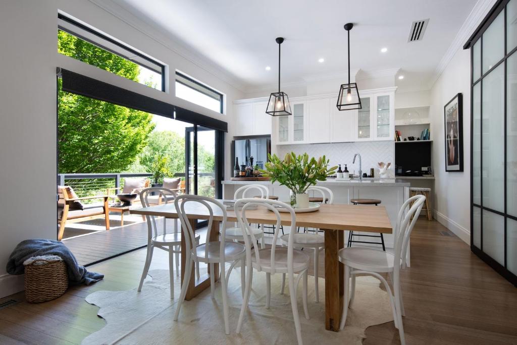 a kitchen and dining room with a wooden table and chairs at Sandringham in Daylesford