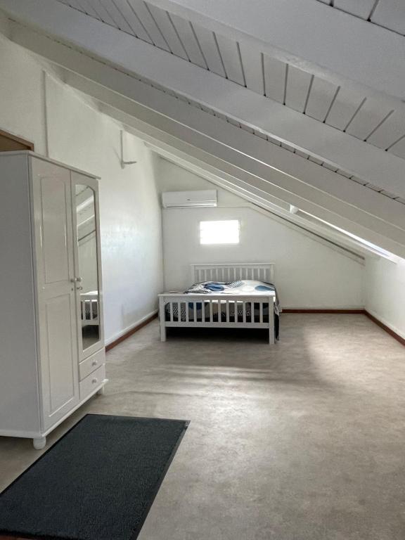 een zolderkamer met een bed en een kast bij Duplex centre-ville in Le Moule