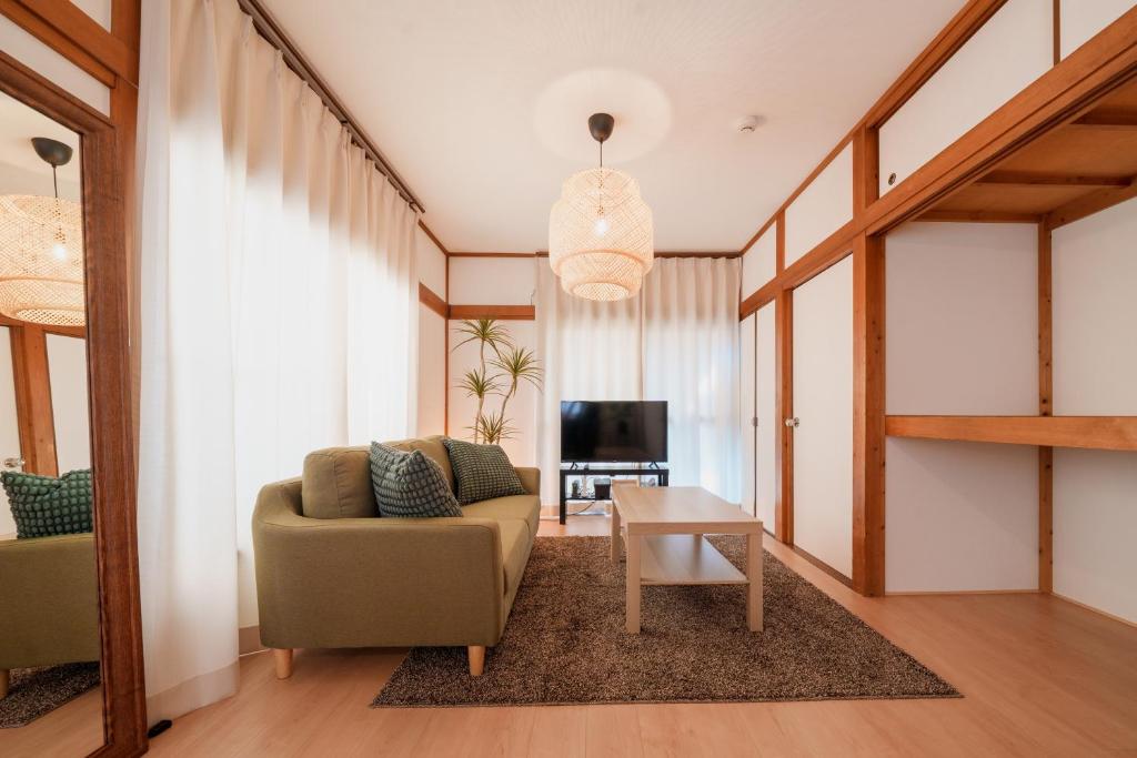 ein Wohnzimmer mit einem Sofa und einem Tisch in der Unterkunft R-house 4th in Tokio